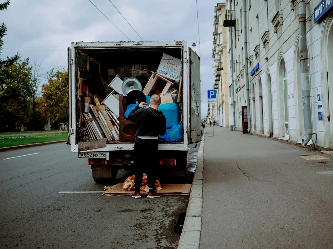 Déménageur chargeant meubles et cartons à l’arrière d’un camion de déménagement, dans une rue
