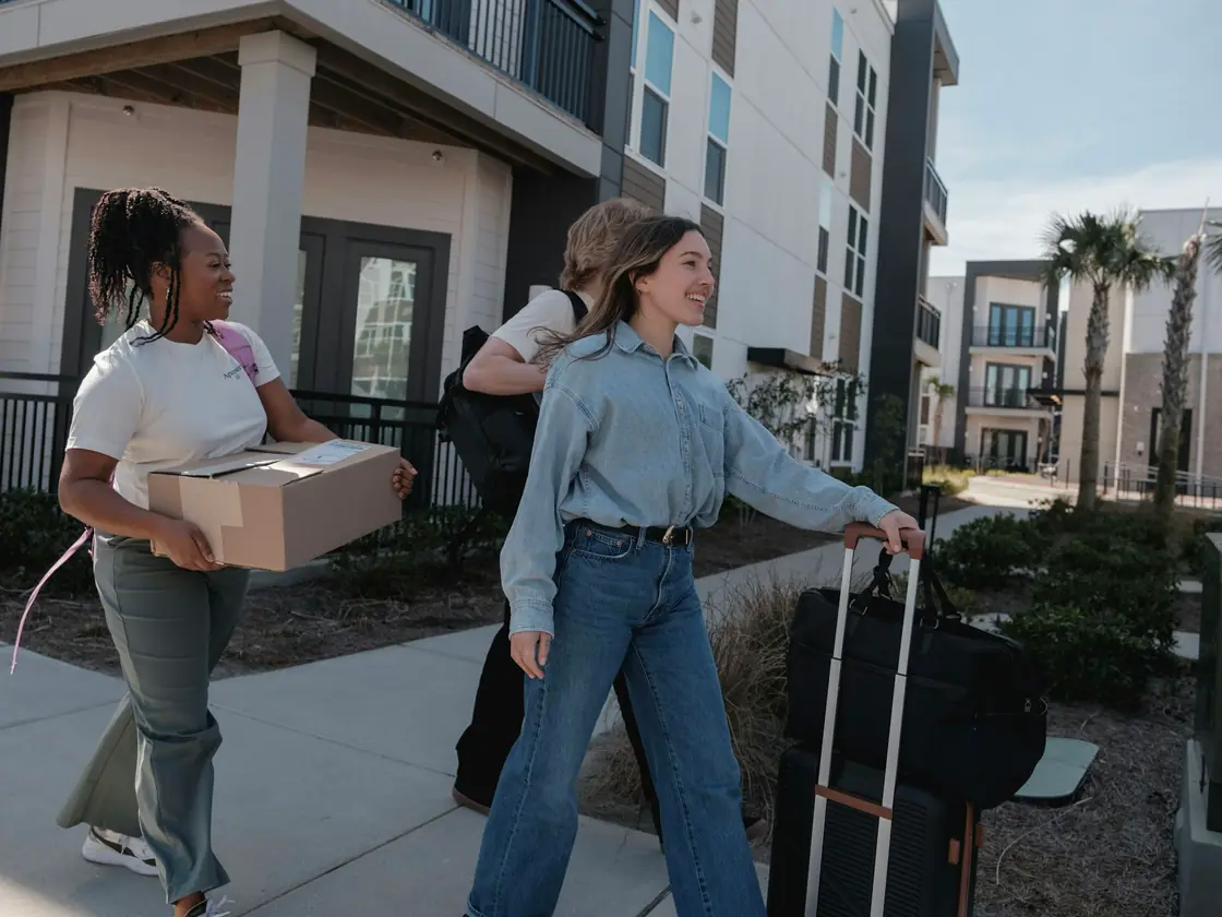 Étudiants transportant cartons et valises devant leur nouveau logement